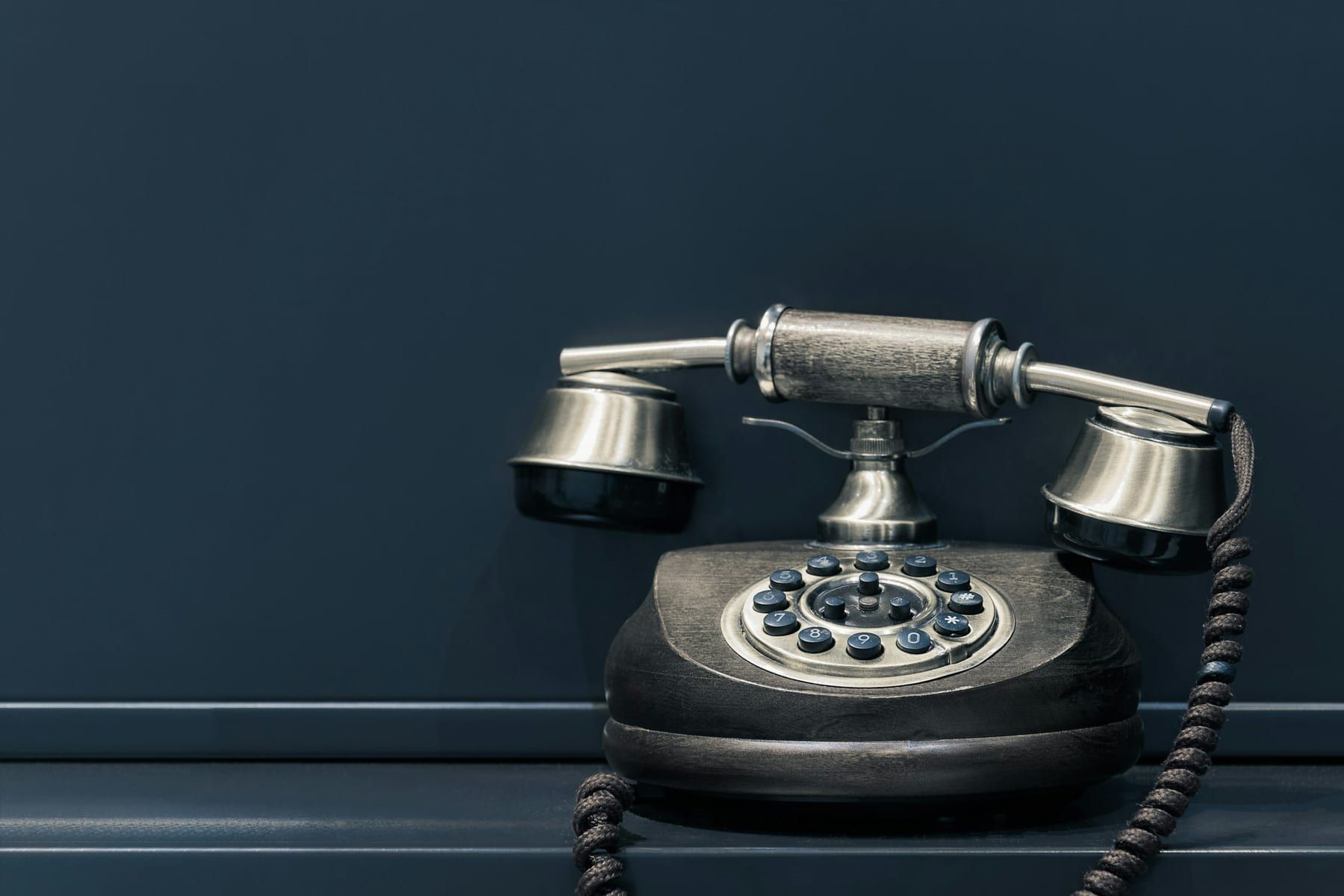 Klassisches Telefon vor dunkelblauer Wand