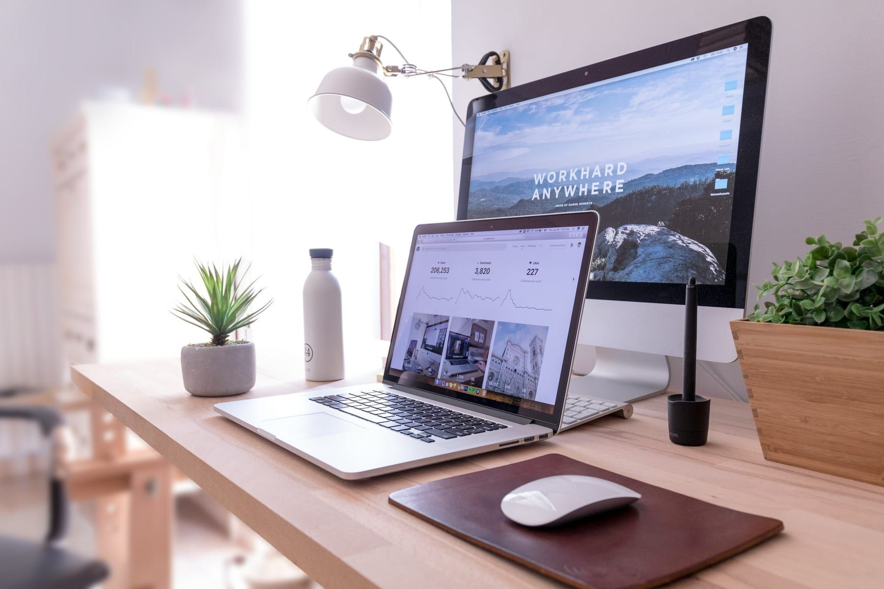 Heller Arbeitsplatz mit Bildschirm und Laptop